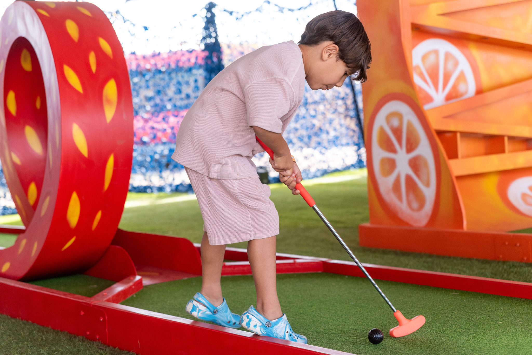 Young guest playing a colourful branded crazy golf course