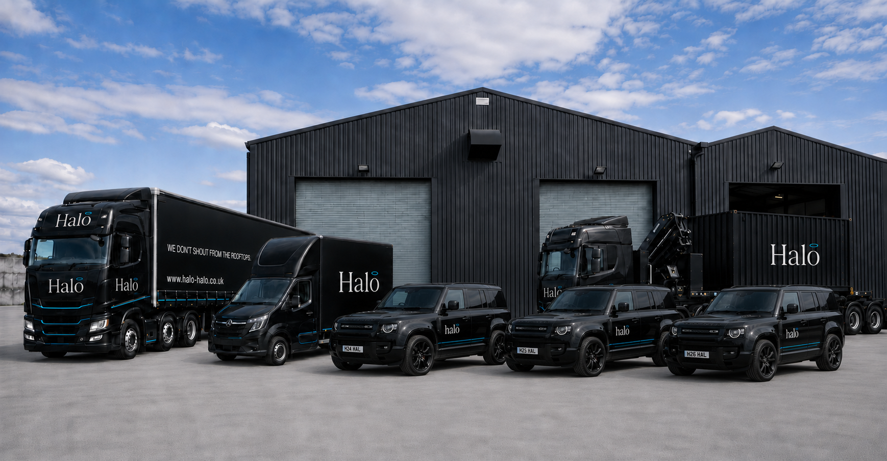 Halo articulated lorry, Luton van, HIAB container vehicle and three modern Defender 110s outside the group warehouse